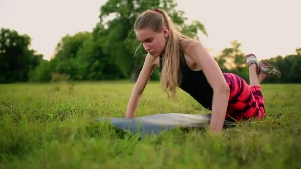 Trois femmes font des pompes sur l'herbe dans le parc — Video