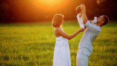 Mutlu aile: anne baba ve kız gün batımında doğada