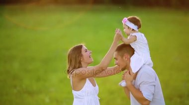 Mutlu aile: anne baba ve kız gün batımında doğada