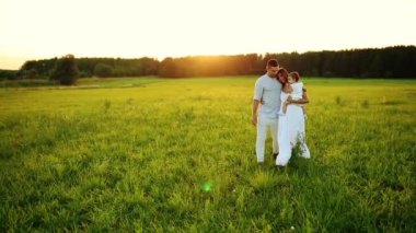 Parkta gün batımında mutlu yedi yürür. Beyaz giysiler, güneş, yaz.