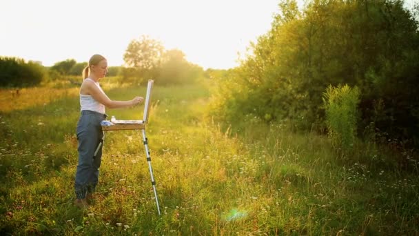 Jeune artiste peignant un paysage d'automne — Video