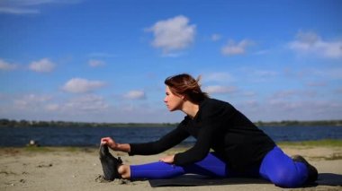 Genç kadın Yoga egzersiz yaz kum plaj günbatımı, egzersiz yaparak.