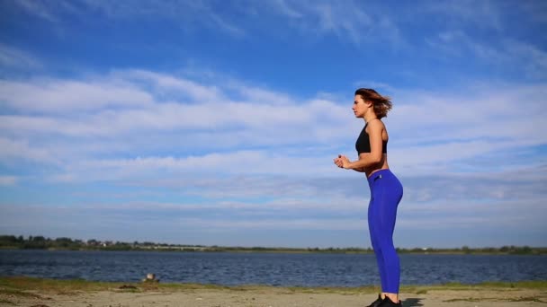 Jovem bela mulher sexy fazendo esportes na praia, nascer do sol, exercícios matinais, ouvir música em fones de ouvido, estilo de vida saudável, exercitar-se, fazendo sit-ups — Vídeo de Stock