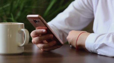 Kadının el cep telefonuyla kahve molası yakın çekim