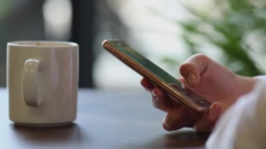 Kadının el cep telefonuyla kahve molası yakın çekim
