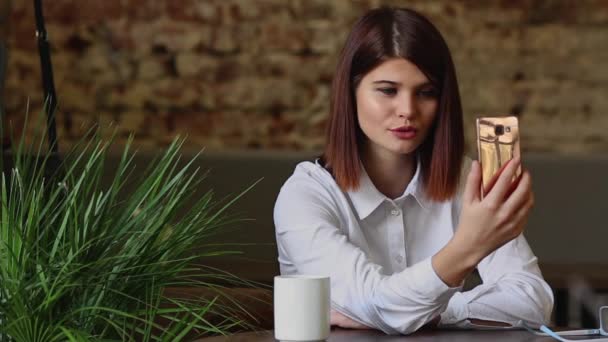 Menina bonita conversando com parceiros de negócios usando uma câmera de telefone móvel . — Vídeo de Stock