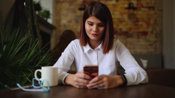 Casual νεαρή γυναίκα που μιλάτε στο τηλέφωνο έχοντας συνομιλία μέσω βίντεο chat διάσκεψη στο σπίτι γραφείο. Επιχειρηματίας χρησιμοποιώντας έξυπνο τηλέφωνο app στο smartphone χαμογελά ευτυχισμένη — Αρχείο Βίντεο