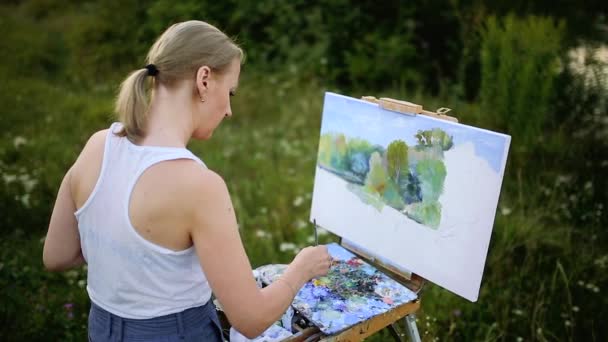 Het meisje met enthousiasme vestigt verven op een papier een landschap — Stockvideo