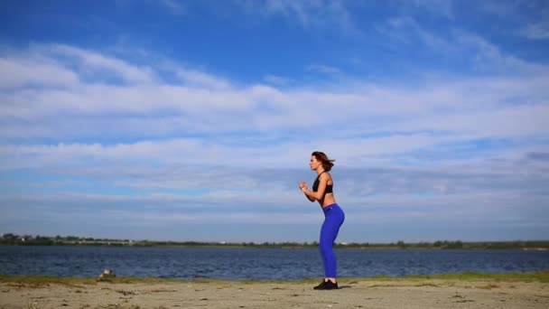 Jovem bela mulher sexy fazendo esportes na praia, nascer do sol, exercícios matinais, ouvir música em fones de ouvido, estilo de vida saudável, exercitar-se, fazendo sit-ups — Vídeo de Stock