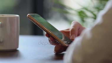 Kadının el cep telefonuyla kahve molası yakın çekim