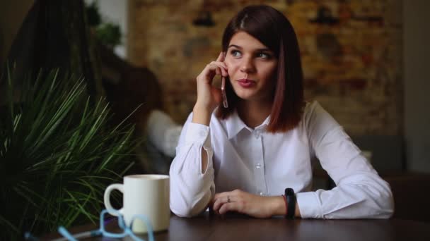 Gelukkig jonge vrouw zittend op de Bank in gezellige doeken met kop koffie — Stockvideo