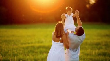 Mutlu aile: anne baba ve kız gün batımında doğada