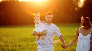 Parkta gün batımında mutlu yedi yürür. Beyaz giysiler, güneş, yaz.