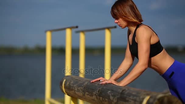 La ragazza viene spinta da un albero vicino al fiume. Primo piano — Video Stock