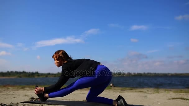 Genç kadın Yoga egzersiz yaz kum plaj günbatımı, egzersiz yaparak. — Stok video