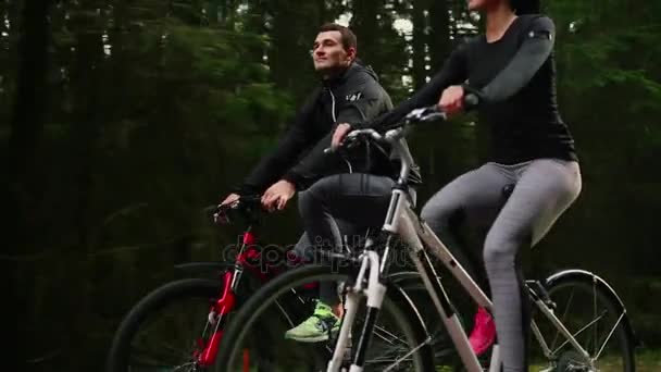 Steadicam tiro de mountain bike casal andando na trilha de bicicleta ao pôr do sol fazendo alta . — Vídeo de Stock