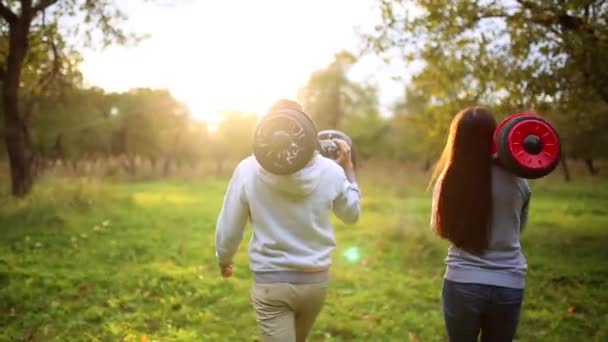 Giovane uomo e donna che cavalcano sull'Hoverboard nel parco. tecnologie dei contenuti. un nuovo movimento. Close Up di doppia ruota auto bilanciamento Skateboard elettrico intelligente. su scooter elettrico all'aperto — Video Stock