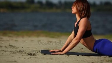 Kız plajda Kobra poz yogadan egzersiz. Yatay kablolama yakın çekim