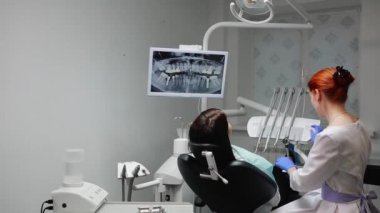 Diş hekimi olan bir hastaya işini tamamlar. Bor makine kaldırır ve bir kız iş değerlendirmek için bir ayna sağlar. Kız görünüyor diş ve diş hekimi teşekkür etti.
