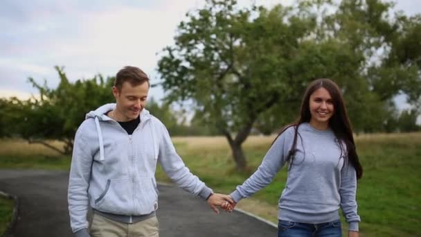 Giovane uomo e donna che cavalcano sull'Hoverboard nel parco. tecnologie dei contenuti. un nuovo movimento. Close Up di doppia ruota auto bilanciamento Skateboard elettrico intelligente. su scooter elettrico all'aperto . — Video Stock