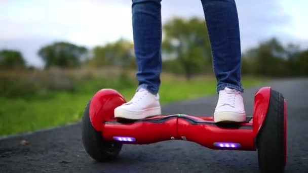 Jovem cavalgando no Hoverboard no parque. tecnologias de conteúdo. um novo movimento. Close Up de dupla roda auto balanceamento skate elétrico inteligente — Vídeo de Stock