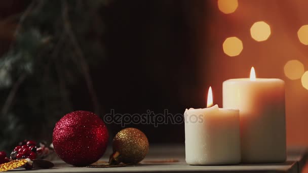 Крупный план. Рождество рука молодой женщины зажигает свечи возле елки на фоне размытого фона — стоковое видео