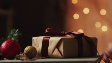 Noel ışıkları eller arka plan üzerinde yakın çekim Kraft kağıt hediye açın. Bokeh arka plan bulanık.