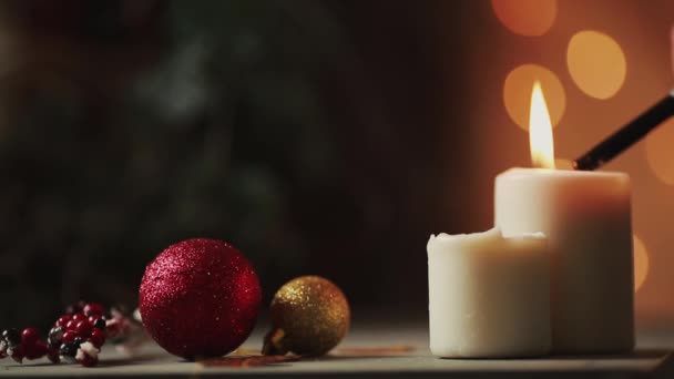 Close-up. Natal a mão de uma jovem mulher acende velas perto da árvore de Natal no fundo do fundo borrado — Vídeo de Stock