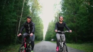 Mutlu genç çift - erkek ve kadın - doğada yaz aylarında Bisiklete binme