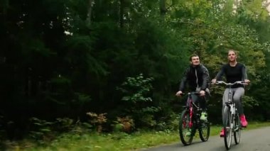 Bisiklet ve ormanın içinde içme suyu ile yürüme çekici çift