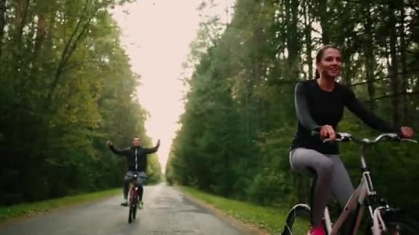 Steadicam disparo de bicicleta de montaña pareja montar en bicicleta sendero al atardecer haciendo alto . — Vídeo de stock