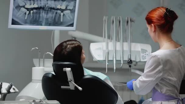 El dentista completa su trabajo con un paciente. Elimina la máquina Bor y le da a una chica un espejo para evaluar el trabajo. La chica te mira los dientes y agradece al dentista . — Vídeos de Stock