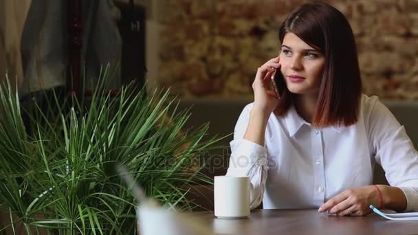 Gelukkig jonge vrouw zittend op de Bank in gezellige doeken met kop koffie — Stockvideo