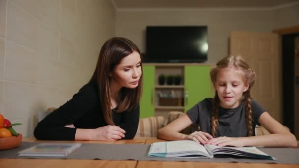 Matka i córka robi praca domowa szkoła. Mama pomaga radzić sobie z nim. — Wideo stockowe