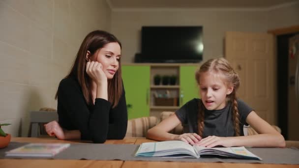 Moeder en dochter doen een huiswerkopdracht school. Moeder helpt te behandelen. — Stockvideo