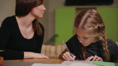 Anne ve kızı bir okul ödevi yapıyor. Anne ile başa çıkmak için yardımcı olur.