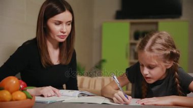 Anne ve kızı bir okul ödevi yapıyor. Anne ile başa çıkmak için yardımcı olur.