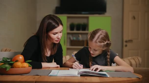 Anya és lánya, csinál egy iskolai házi feladat. Anyu, segít foglalkozni vele. — Stock videók