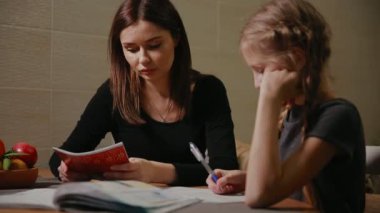 Anne ve kızı bir okul ödevi yapıyor. Anne ile başa çıkmak için yardımcı olur.