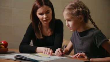 Anne ve kızı bir okul ödevi yapıyor. Anne ile başa çıkmak için yardımcı olur.