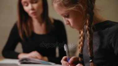 Anne ve kızı bir okul ödevi yapıyor. Anne ile başa çıkmak için yardımcı olur.