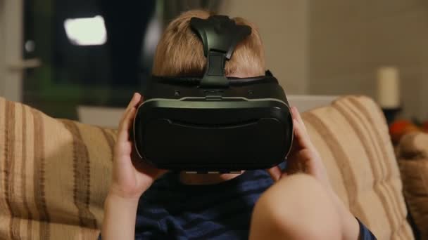 Junge 6-7 Jahre spielen zu Hause mit Hilfe von Virtual-Reality-Brillen Videospiele. Nahaufnahme — Stockvideo