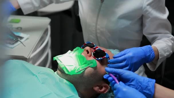 Le dentiste et l'infirmière réparent la dent d'un patient. L'utilisation de bormashenko pour percer les dents et éliminer la carie dentaire et l'étanchéité . — Video