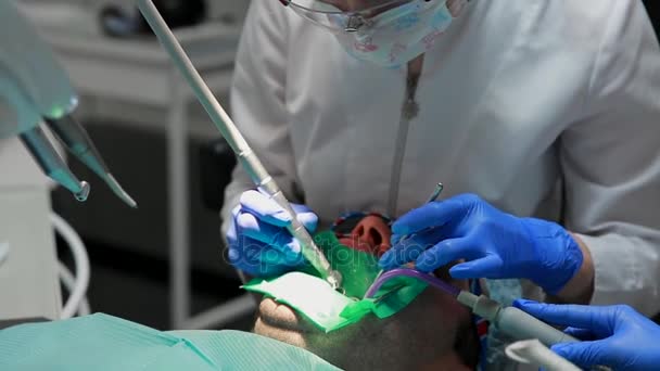 Zubař a sestra oprava zubu trpělivý muž. Využívání bormashenko na zuby a odstranit zubní kaz a těsnění. — Stock video
