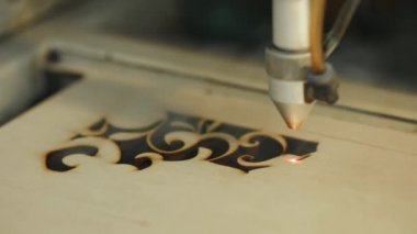 Makine lazer kesim tahta yakın kesim Sunta ve duman için görünür. Kırmızı ışın.