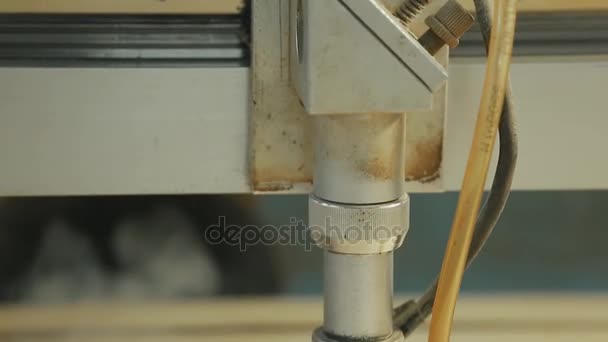 Machine de découpe laser bois gros plan découpe des panneaux de particules et la fumée apparaît. Le faisceau rouge .