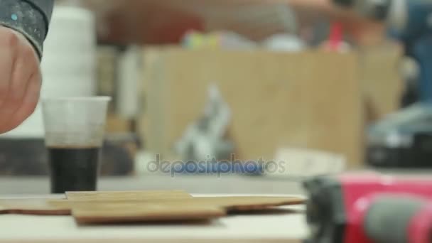 Primo piano di mano maschile di una macchia di legno professionale prodotti macchia nell'impresa . — Video Stock
