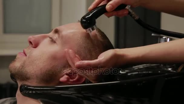 Une femme se lave les cheveux dans le salon de coiffure barbu homme avec shampooing et revitalisant. Laver l'eau du shampooing . — Video