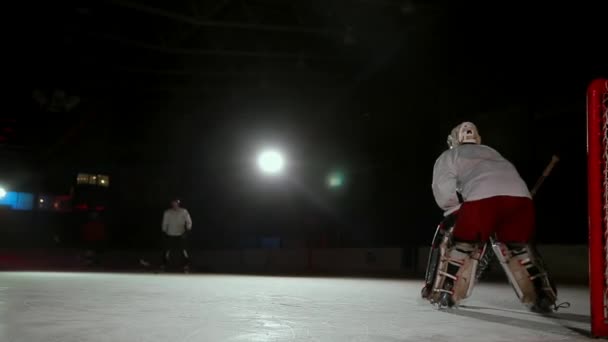 Eishockeyprofis spielen das Shootout. Der Spieler, der den Elfmeter hält, ist ein Eishockey-Torhüter. Schwebestativ. — Stockvideo