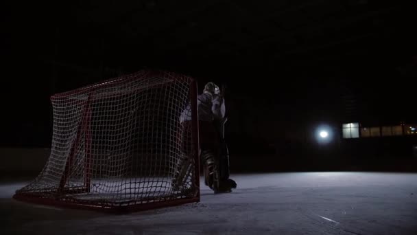 Eishockeyprofis spielen das Shootout. Der Spieler, der den Elfmeter hält, ist ein Eishockey-Torhüter. Schwebestativ. — Stockvideo